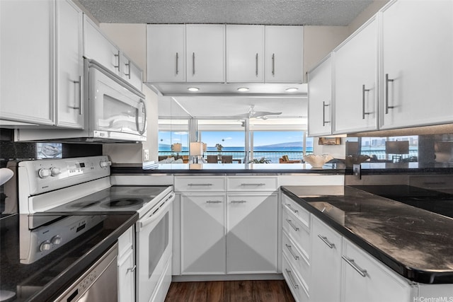 2877 Kalakaua Ave Unit 503/504, Honolulu, HI 96815 - kitchen featuring white appliances, white cabinetry, dark wood-style floors, dark countertops, and a textured ceiling