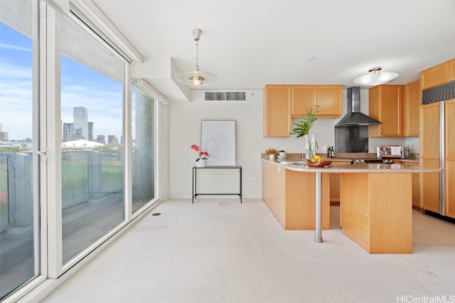 kitchen with wall chimney exhaust hood, paneled refrigerator, light carpet, and light brown cabinetry