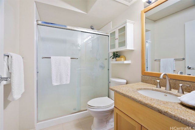 bathroom featuring vanity, toilet, tile patterned floors, and an enclosed shower