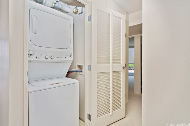 clothes washing area with stacked washer and clothes dryer