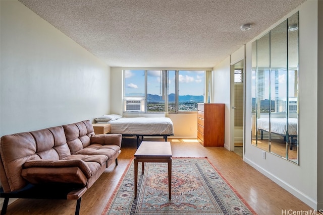 bedroom with a mountain view, a textured ceiling, and wood-type flooring