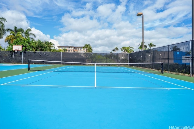 view of tennis court featuring basketball hoop