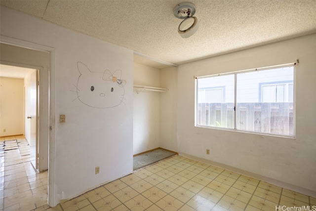 unfurnished room featuring a textured ceiling