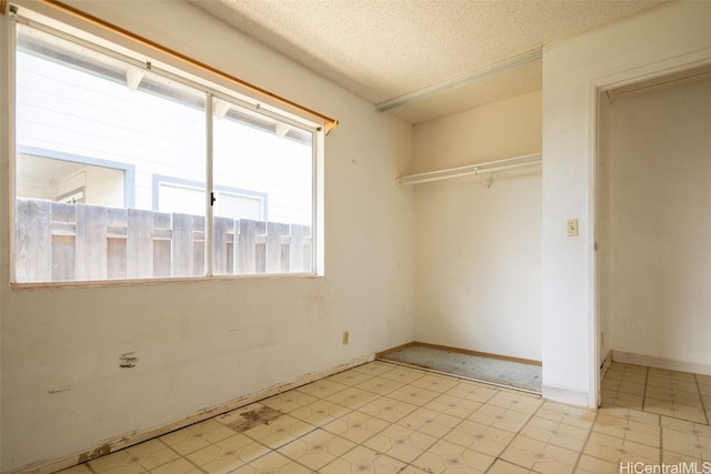 unfurnished room featuring a textured ceiling