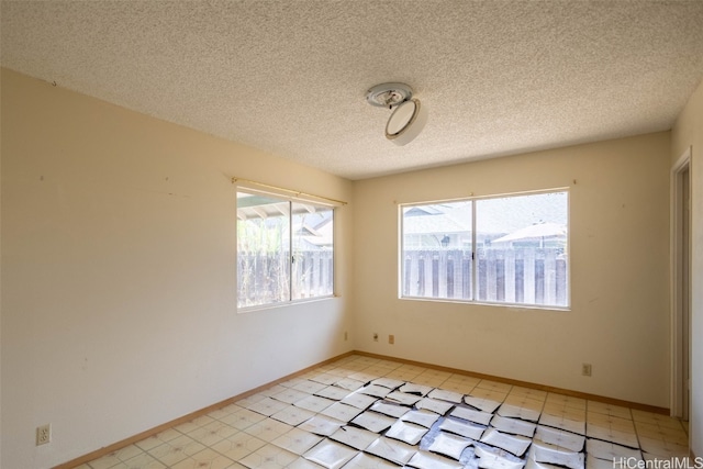 tiled spare room with a textured ceiling