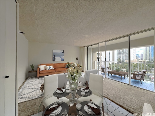 dining space with light carpet and a textured ceiling