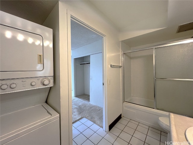 interior space featuring stacked washing maching and dryer and light tile patterned floors