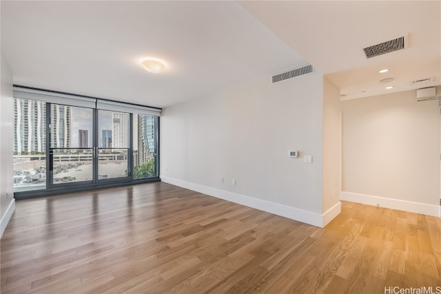 empty room with expansive windows and light wood-type flooring