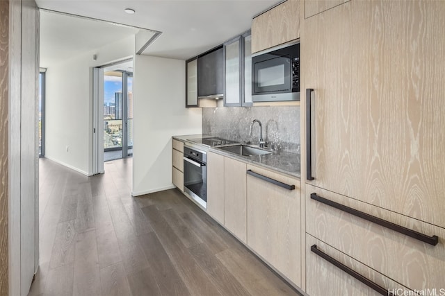 kitchen with sink, backsplash, dark hardwood / wood-style flooring, stainless steel appliances, and light brown cabinets