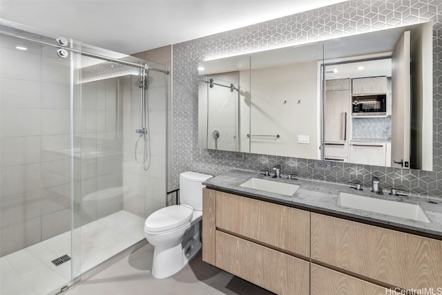 bathroom featuring tasteful backsplash, tile walls, toilet, vanity, and an enclosed shower