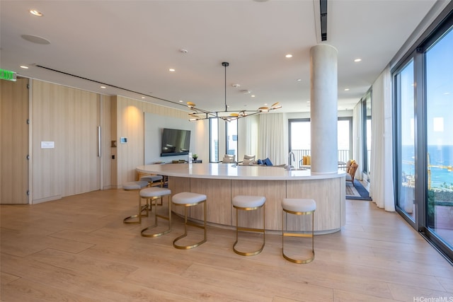 987 Queen St Unit 508, Honolulu, HI 96814 - kitchen featuring light wood-style flooring, light countertops, open floor plan, and a large island with sink