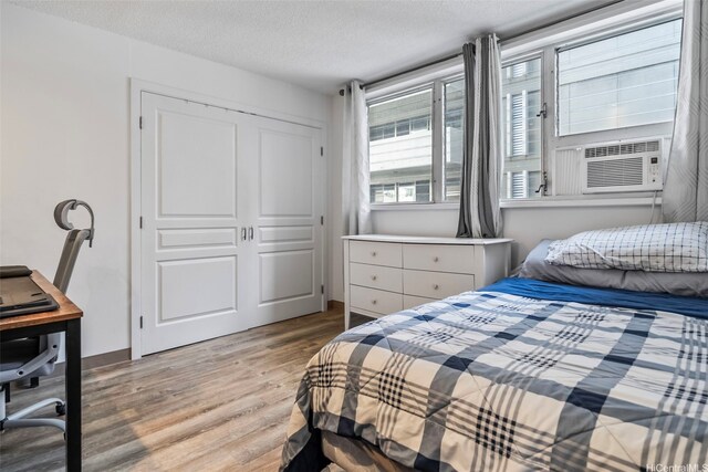 2355 Ala Wai Blvd Unit 201, Honolulu, HI 96815 - bedroom featuring light wood-style flooring, cooling unit, a textured ceiling, a closet, and an office area