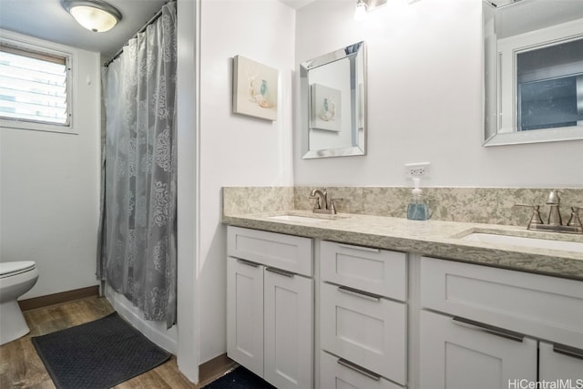 bathroom with toilet, curtained shower, hardwood / wood-style flooring, and vanity