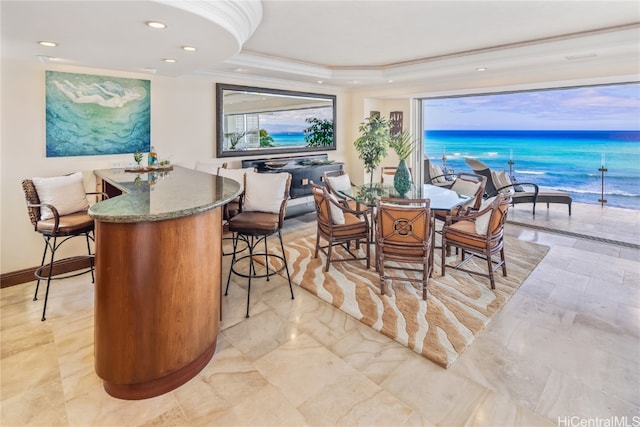 dining room with a water view and crown molding