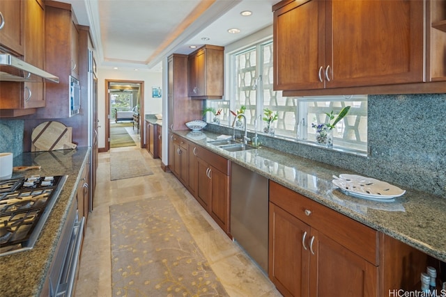 kitchen featuring stone countertops, appliances with stainless steel finishes, sink, and decorative backsplash