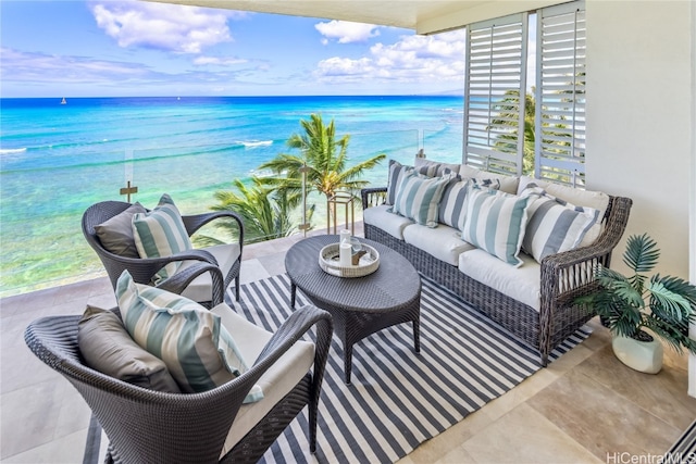 balcony featuring outdoor lounge area, a water view, and a beach view