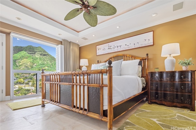 bedroom with crown molding, a tray ceiling, and ceiling fan