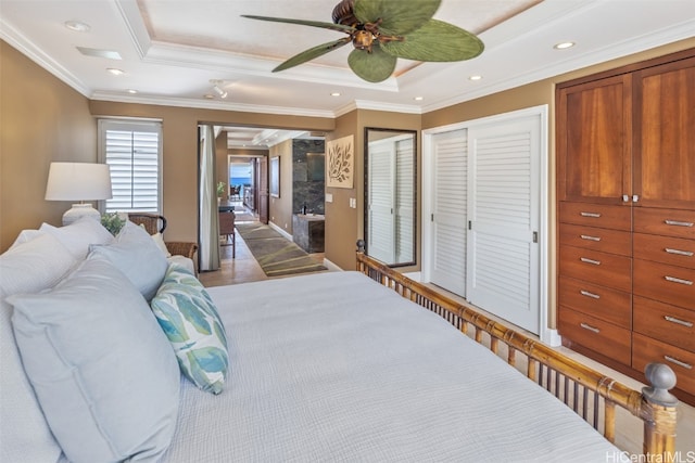 bedroom featuring crown molding, a raised ceiling, and ceiling fan