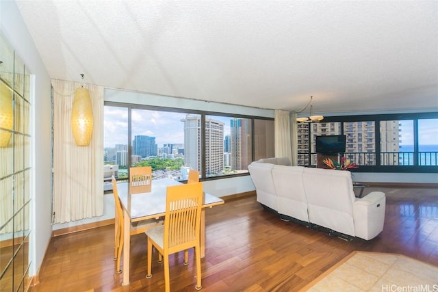 dining area with hardwood / wood-style floors, a textured ceiling, and a chandelier