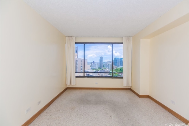 carpeted spare room featuring a textured ceiling