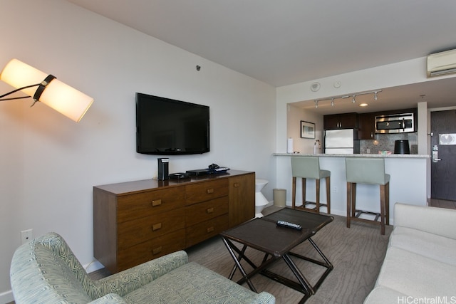 living room featuring a wall mounted air conditioner, sink, and track lighting