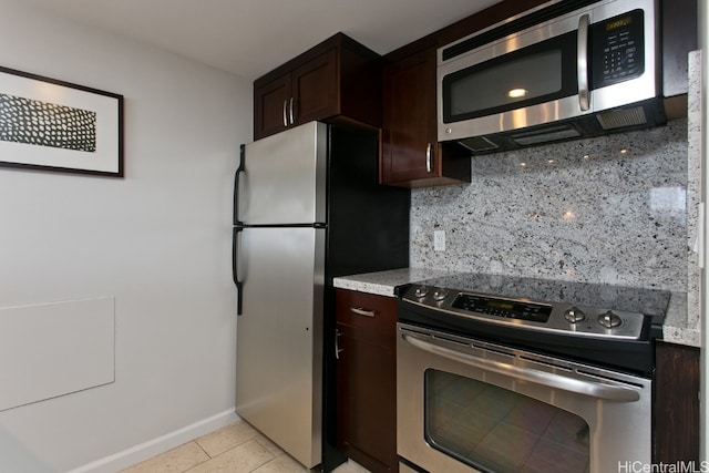 kitchen with appliances with stainless steel finishes, dark brown cabinetry, tasteful backsplash, and light tile patterned floors