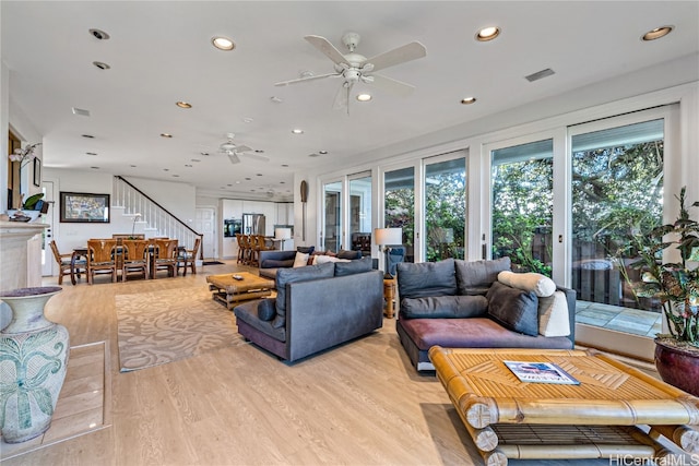 living room with light hardwood / wood-style floors and ceiling fan