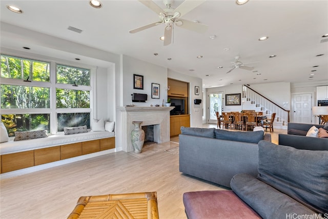 living room with light hardwood / wood-style flooring and ceiling fan