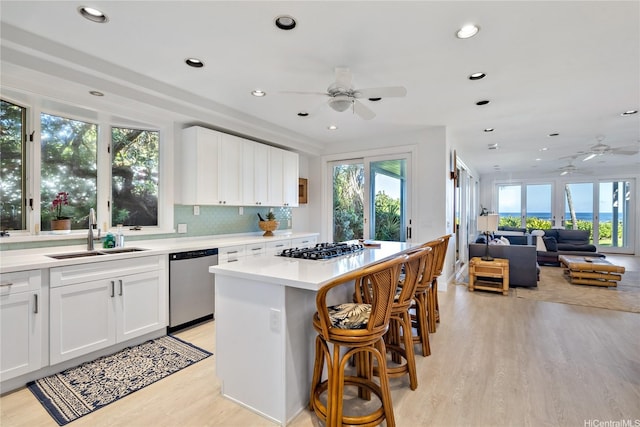 68-421 Crozier Dr, Waialua, HI 96791 - kitchen featuring stainless steel appliances, ceiling fan, a sink, light wood-style floors, and a center island
