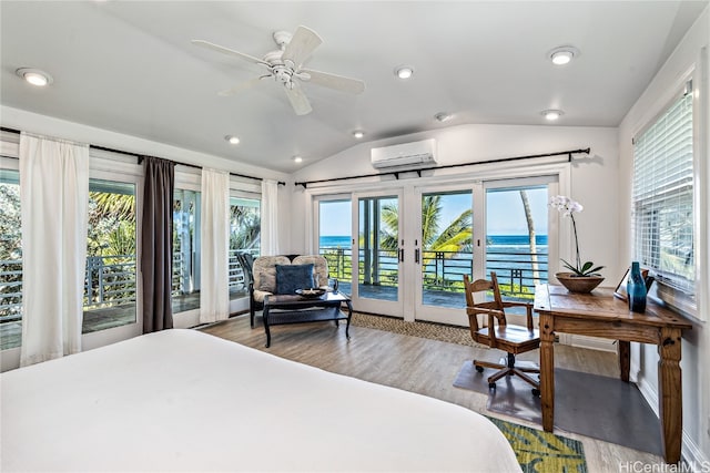 bedroom featuring vaulted ceiling, a wall mounted AC, multiple windows, and a water view