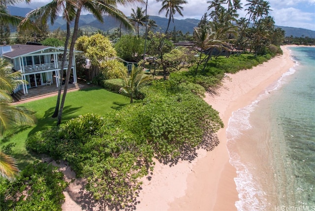 drone / aerial view with a water and mountain view and a beach view