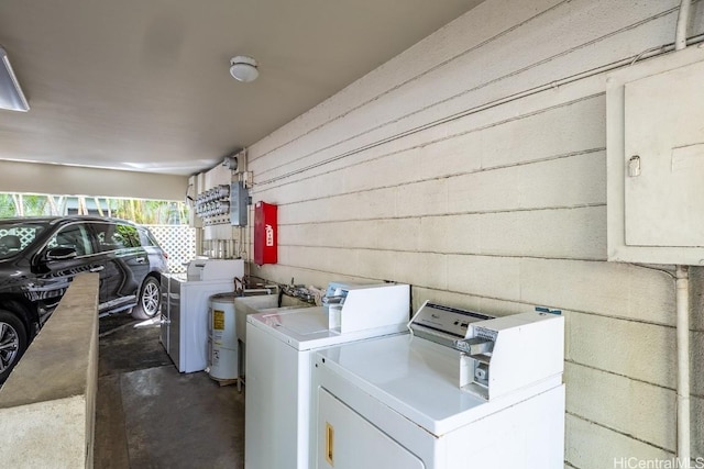 laundry area with electric panel and separate washer and dryer