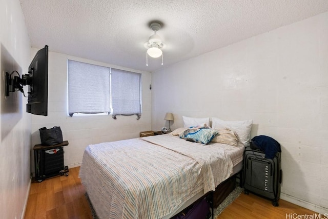 bedroom featuring ceiling fan, a textured ceiling, and hardwood / wood-style flooring