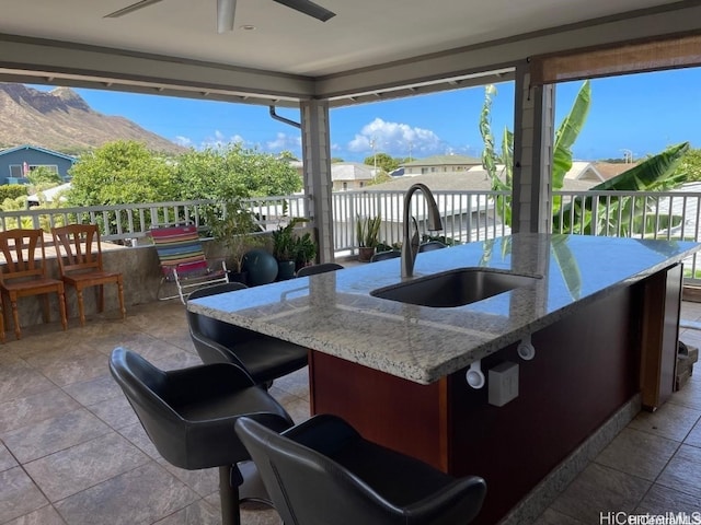 view of patio / terrace featuring ceiling fan, a mountain view, and a wet bar