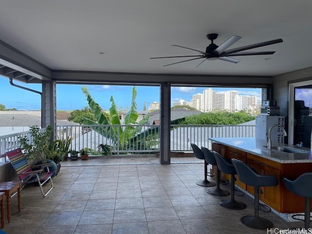 sunroom / solarium featuring ceiling fan and sink