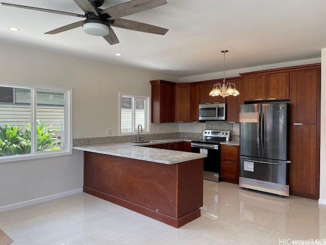 kitchen featuring sink, backsplash, kitchen peninsula, stainless steel appliances, and pendant lighting