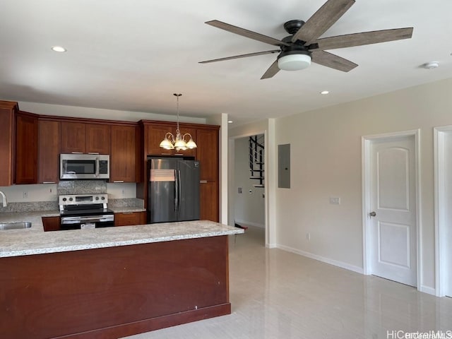 kitchen featuring electric panel, hanging light fixtures, appliances with stainless steel finishes, ceiling fan with notable chandelier, and sink