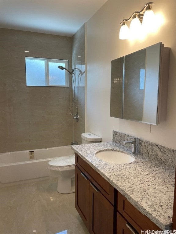 full bathroom featuring vanity, tiled shower / bath combo, and toilet