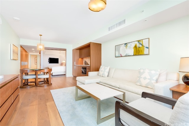 living room with light hardwood / wood-style flooring and a chandelier