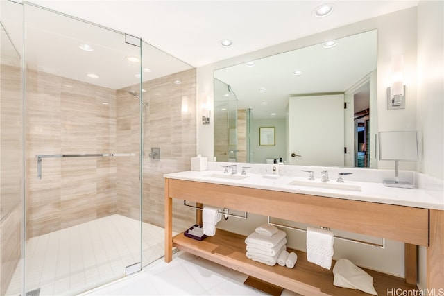 bathroom featuring a shower with door and vanity