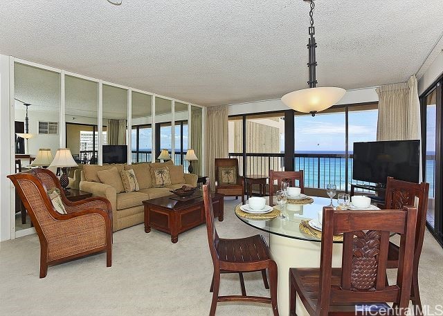 carpeted dining space featuring a textured ceiling and plenty of natural light