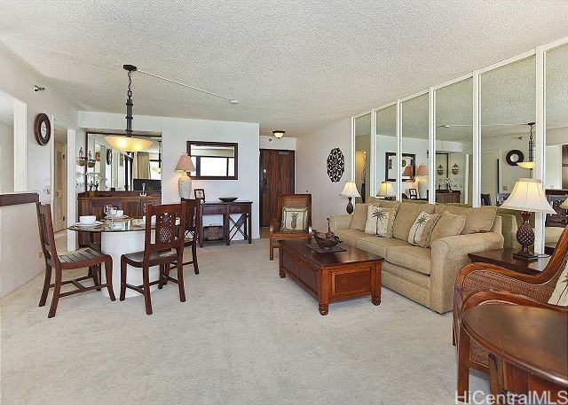 living room featuring light carpet and a textured ceiling