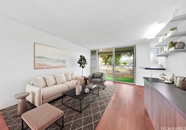 living room featuring a textured ceiling, a wall of windows, and wood finished floors