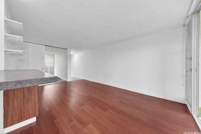 647 Kunawai Ln Unit B203, Honolulu, HI 96817 - unfurnished living room with a textured ceiling, wood finished floors, and baseboards