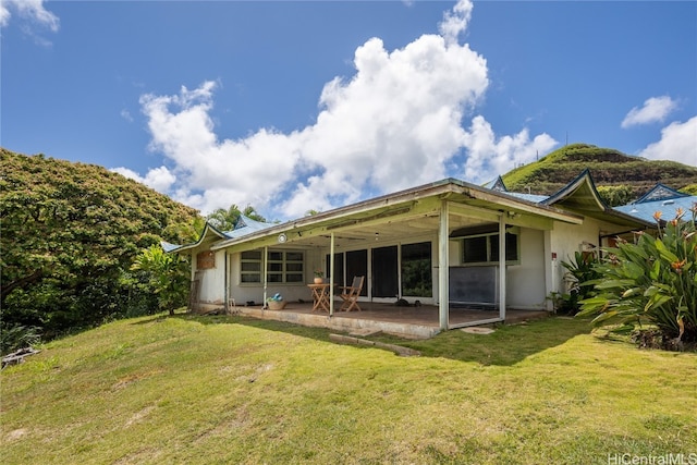 rear view of house featuring a patio and a lawn