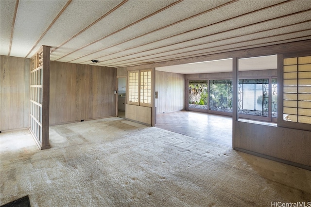 empty room with a textured ceiling and wooden walls