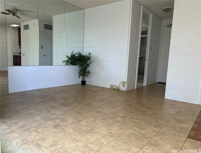 empty room featuring a textured ceiling and ceiling fan