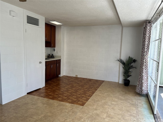 kitchen with a textured ceiling and light parquet flooring