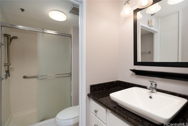 bathroom featuring toilet, an enclosed shower, and vanity