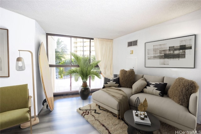 living room featuring a wall of windows, a textured ceiling, and wood-type flooring